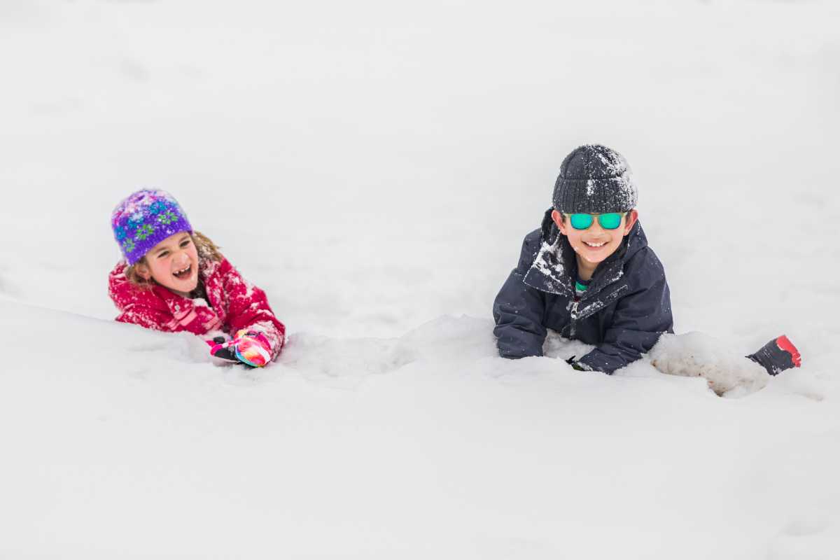 Panorama del castello di Fénis in inverno, con bambini che giocano nella neve.
